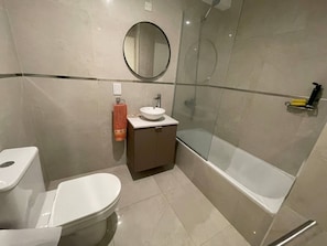 A modern bathroom with a toilet, sink, and glass-enclosed shower. - Comfortable and Elegant With Heated Pool (Buenos Aires)