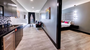 Une chambre d’hôtel moderne dotée d’un coin cuisine, d’une table à manger et d’un grand lit.