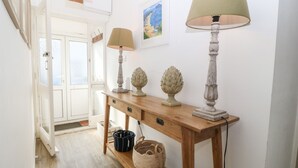 A hallway with a wooden console table, two lamps, and decorative vases. - Llwyn Onn (Pwllheli)
