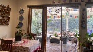 A cozy dining area with a table set for two, a wooden chair, and a potted plant.