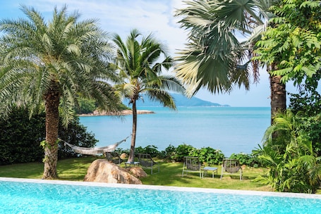 Una piscina al aire libre, sillones reclinables de piscina