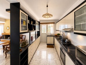 A modern kitchen with marble flooring, built-in cabinetry, and a pendant light. - Eagles Nest Villa Your Grecian Paradise (Kropia)