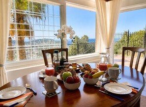 Une table à manger dressée pour le petit-déjeuner, avec vue sur le paysage.
