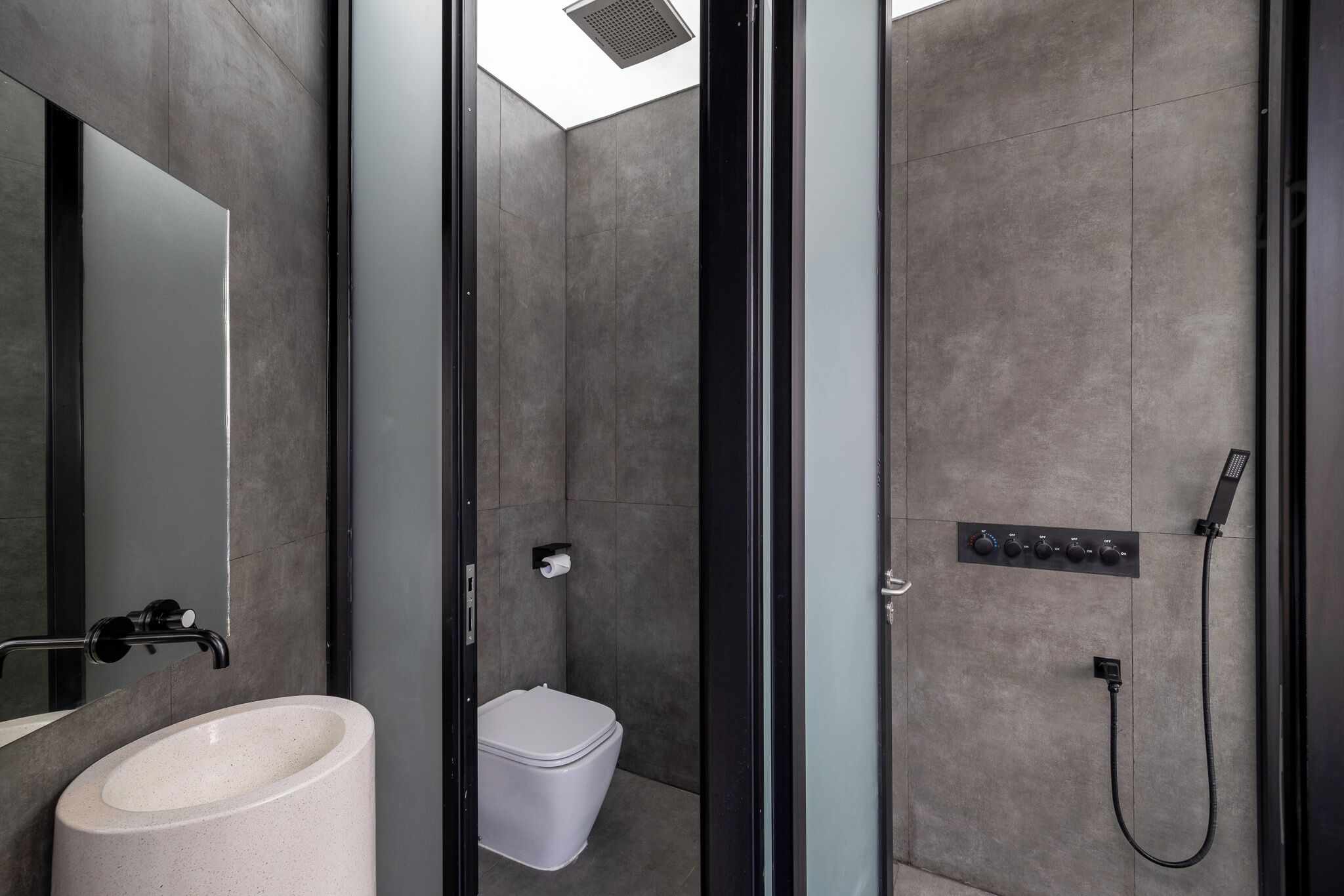 Ein modernes Badezimmer mit einem großzügigen Waschbecken, Toilette und Duschbereich.