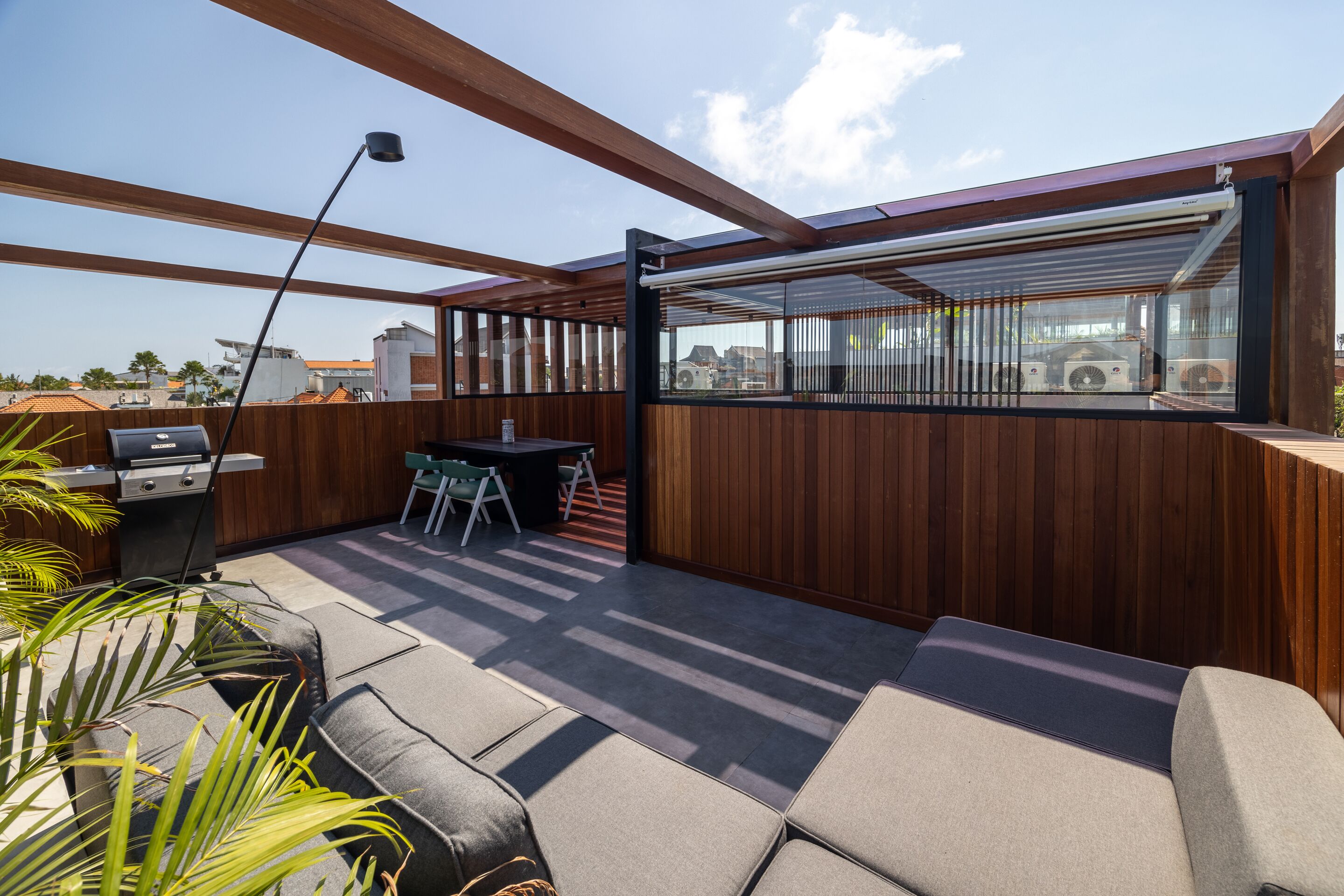 Une terrasse extérieure avec des poutres en bois, un barbecue et des sièges.