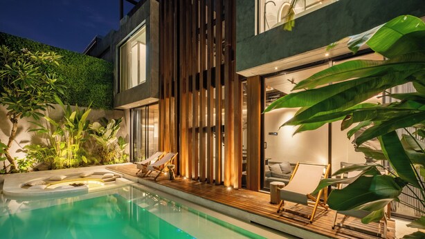 A modern outdoor pool area with lounge chairs and a wooden deck. - Alex Villas Complex N2 (Canggu)
