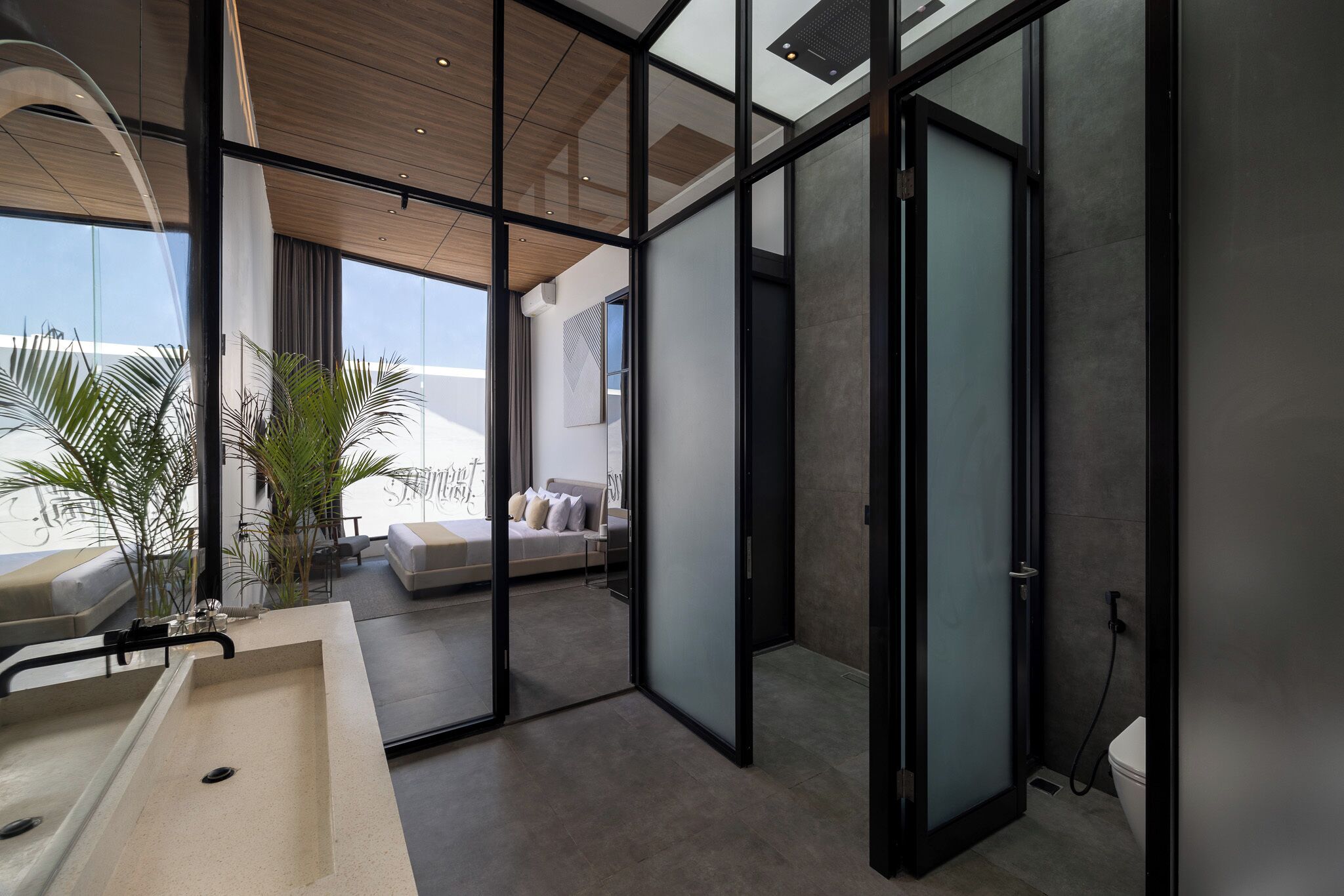 A modern bathroom with a large glass shower enclosure, a bathtub, and a toilet.