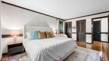 A bedroom with a bed, bedside tables, a lamp, a chair, and a wardrobe.