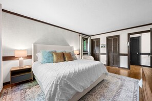 A bedroom with a bed, bedside tables, a lamp, a chair, and a wardrobe.