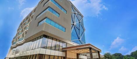 Un edificio moderno con una fachada de vidrio destacada y un diseño geométrico.