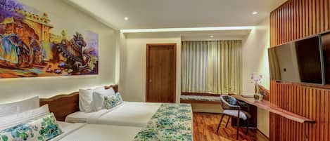 A hotel room with two beds, a desk, a chair, a TV, and a large painting on the wall.