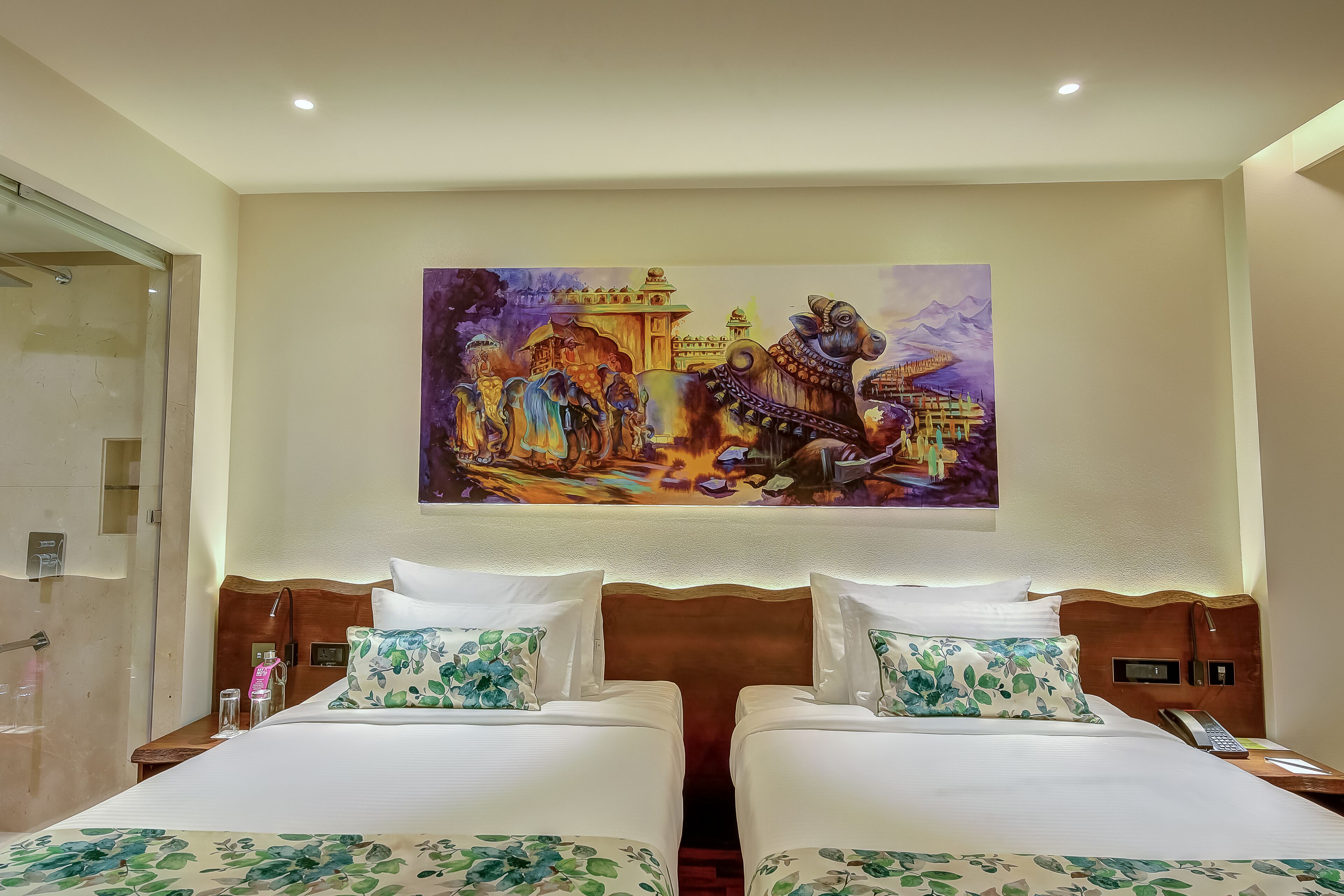 Habitación de hotel con dos camas, ducha, un cuadro de un palacio y una mesita de noche con un teléfono.