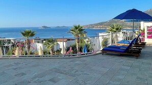 Eine Terrasse mit Lounge-Möbeln und Blick aufs Meer.