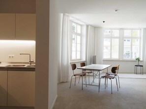 Een moderne keuken met een inbouwspoelbak en een eethoek met een tafel en vier stoelen.