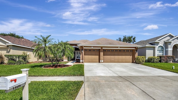 A residential house with a garage, a driveway, and a mailbox. - Valrico's Hidden Gem: A Stunning 3-Bedroom Oasis Awaits! (Valrico)