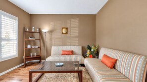 A living room with a sofa, armchair, coffee table, and a bookshelf. - Valrico's Hidden Gem: A Stunning 3-Bedroom Oasis Awaits! (Valrico)