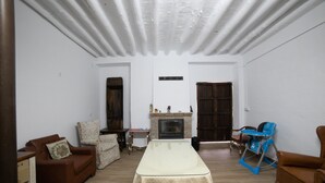 A spacious living room with a long table, sofas, and a fireplace. - El Parador de Carmencita Casa Rural Capacidad 19 Personas (Almedinilla)