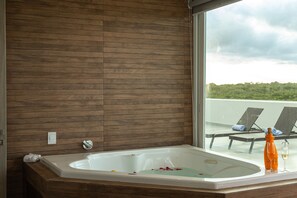 Relax in a spacious bathroom with a large bathtub and a view of the rooftop terrace.