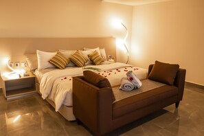 Relax in comfort with a large bed, sofa, and bedside table, perfect for unwinding.