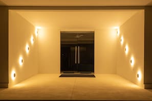 Relax in a serene space with a central area for lounging and a glass partition offering a view of the outdoors.