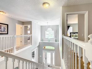 Experience the classic design of this multi-level space, featuring a vaulted ceiling and large window with decorative details.