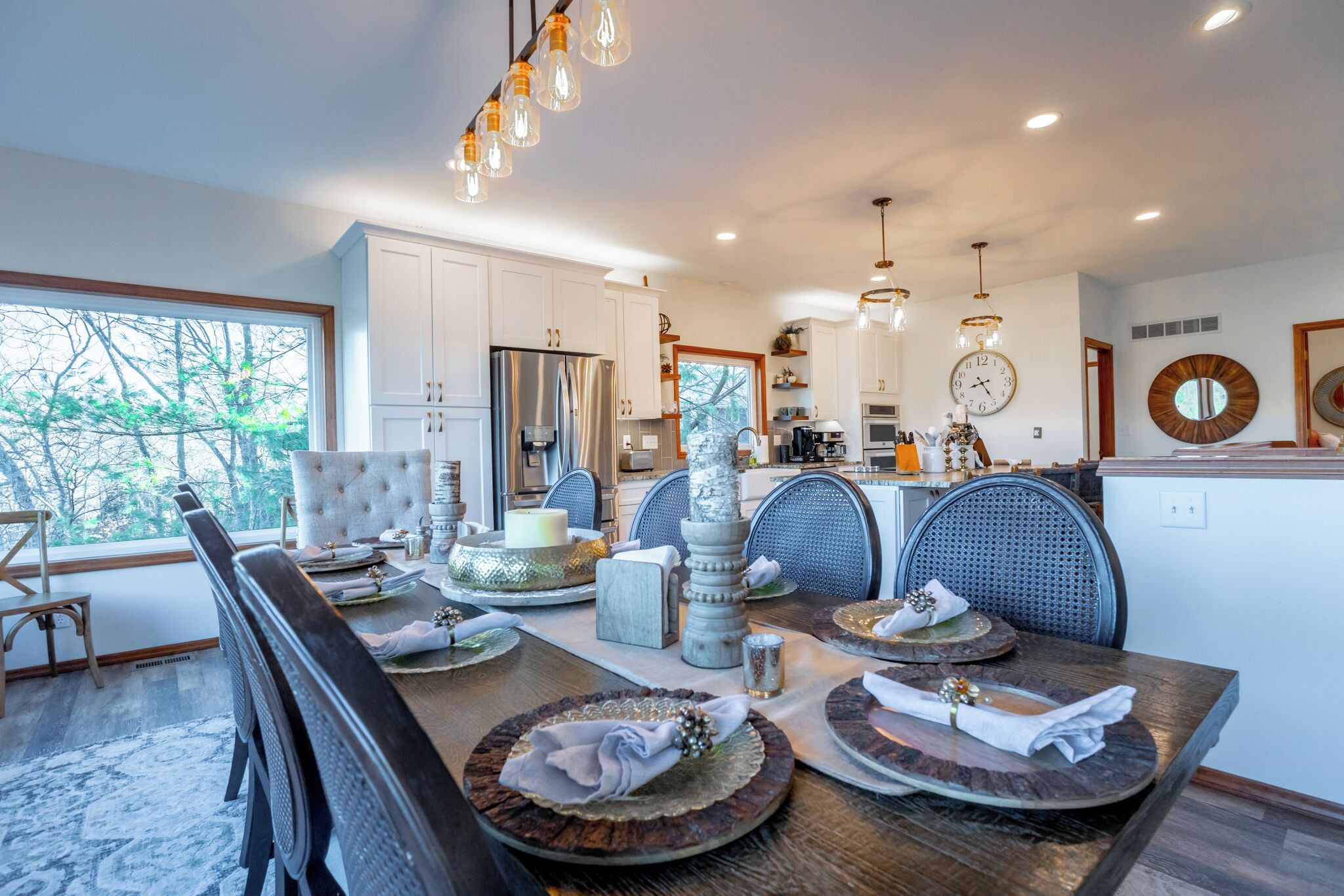 A modern dining area with a large table set for a meal, surrounded by high-backed chairs.