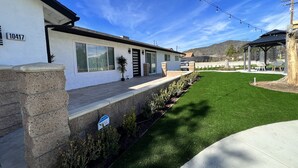 Una casa moderna con fachada de piedra, ventanas amplias y un césped bien cuidado.