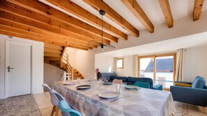 A dining area with a table set for four, a staircase, and a sofa in the background. - Sea view - House for 7 with balcony (Saint-Pierre-Quiberon)