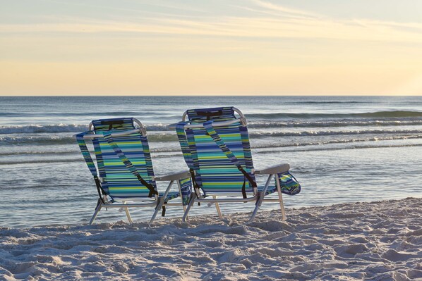 Two beach chairs with striped cushions facing the ocean. - Gulf View Retreat with Beach Service at Sterling Shores (Destin)