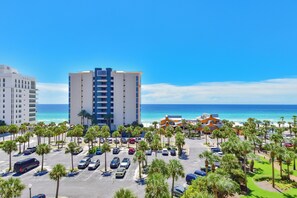 Ein Strandhotel mit mehreren Parkebenen, einem Poolbereich und Meerblick.