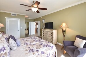 A bedroom with a bed, dresser, chair, ceiling fan, and a television. - Relaxing Gulf View Condo with Private Beach at Sterling Shores (Destin)