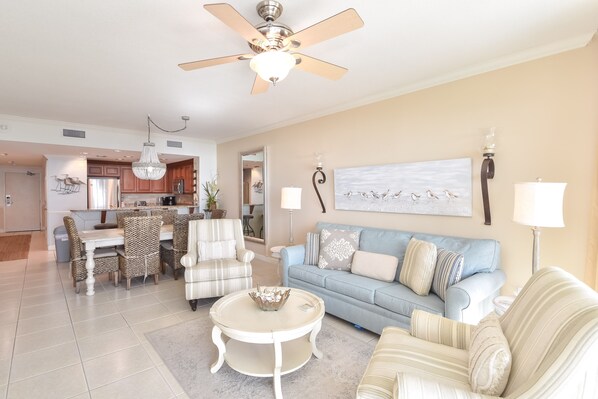 A spacious living area with a dining table, chairs, a sofa, and a ceiling fan. - Relaxing Gulf View Condo with Private Beach at Sterling Shores (Destin)