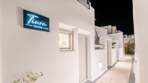 A hotel corridor with a neon sign for 'Tiara Suites'. - Tiara Suites (Santorini)