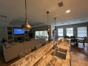 Enjoy a spacious kitchen and living area with a central island, flat-screen TV, and dining table.