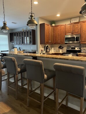 Enjoy cooking in this well-lit kitchen with a central island and stainless steel appliances.