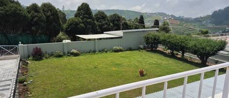 A courtyard with a lawn, a small tree, and a building with a flat roof.