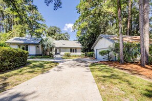 A two-story house with a front yard, a driveway, and a small front porch.