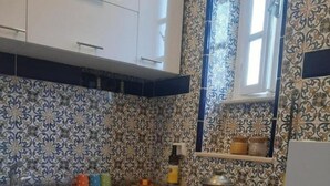 Cocina con gabinetes blancos, encimera de granito, estufa a gas y un lavabo.