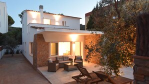 Een modern huis met een patio, meubilair en een stenen muur.