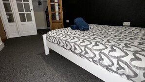 A bedroom with a bed, a wardrobe, and a door.