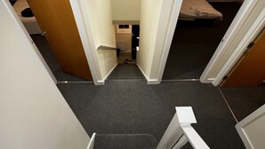 A staircase leading to a bedroom with a bed and a window.