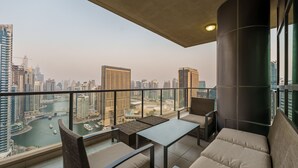 Un balcon avec vue sur le paysage urbain et la rivière. Il y a deux tables et quatre chaises.