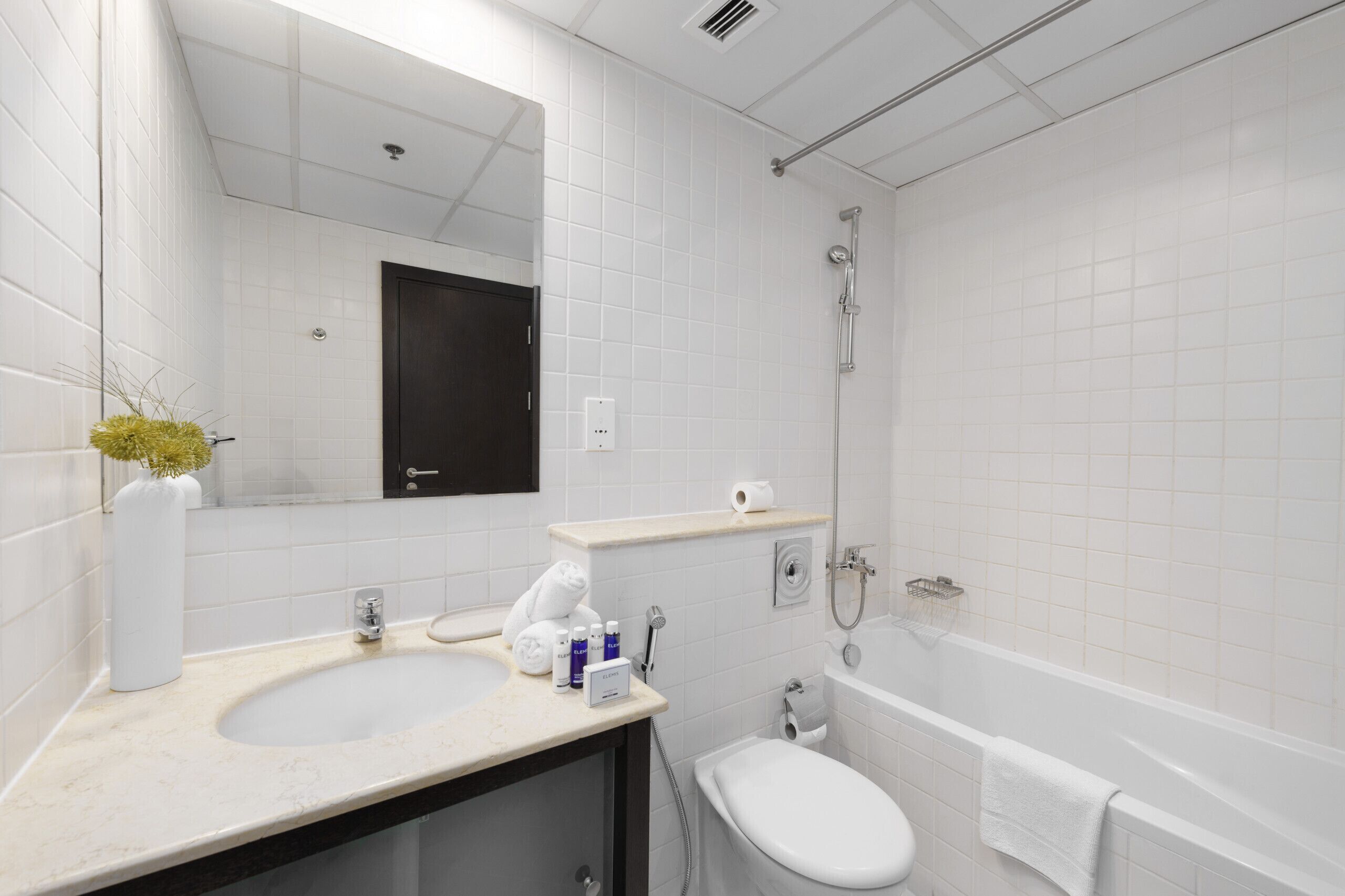 Ein modernes Badezimmer mit einem weißen Waschbecken, einer Toilette und einer Badewanne.