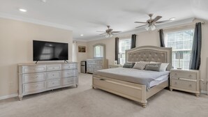 A bedroom with a large bed, two bedside tables, a dresser, a television, and two ceiling fans. - Leo Farm Villa - Beautiful Country Retreat 5 Bedroom Villa by RedAwning (Bel Alton)