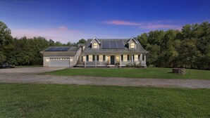 A two-story house with a garage, solar panels, and a well-maintained lawn. - Leo Farm Villa - Beautiful Country Retreat 5 Bedroom Villa by RedAwning (Bel Alton)