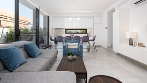 Sala de estar moderna com sofá, mesa de centro e área de jantar.