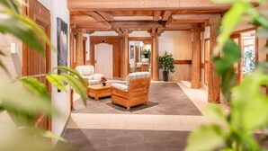 A cozy lobby with wooden beams, a sofa, a chair, and a coffee table. - 1st floor, fitness, swimming pool, sauna, hammam, terrace, parking, tv, 58m², Champagny-en-Vanoise (Champagny-en-Vanoise)