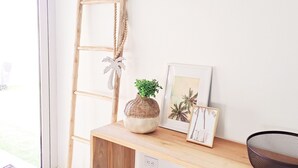 A wooden desk with a woven basket, a small plant, and a framed picture of palm trees. - Buba Villa 1 with 3 Master Bedrooms within walking distance of Eagle Beach (Noord)