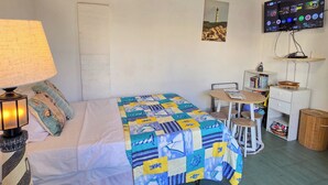 A bedroom with a bed, a desk, a chair, a TV, and a lamp. - Studio Lighthouse, Walking - 10 min to the beach (Noord)