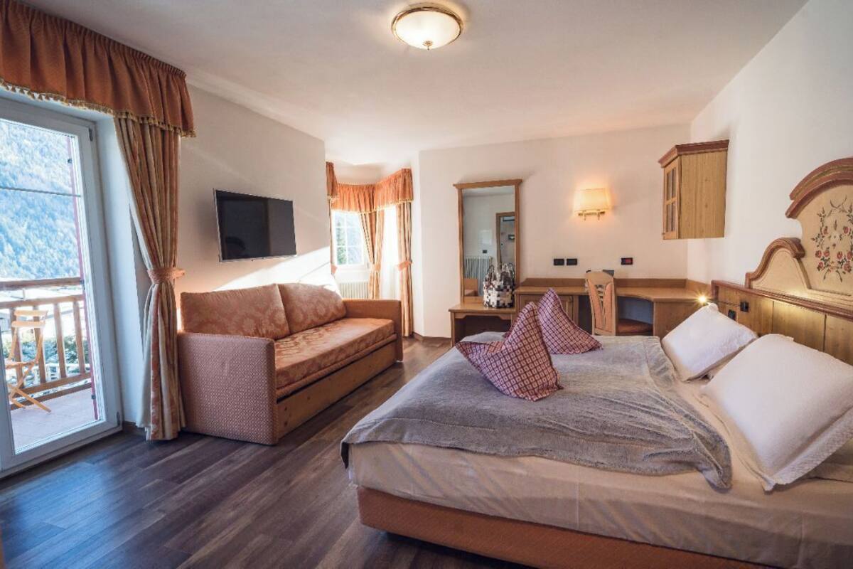 Une chambre à coucher avec un lit, un canapé, un bureau et une télévision.